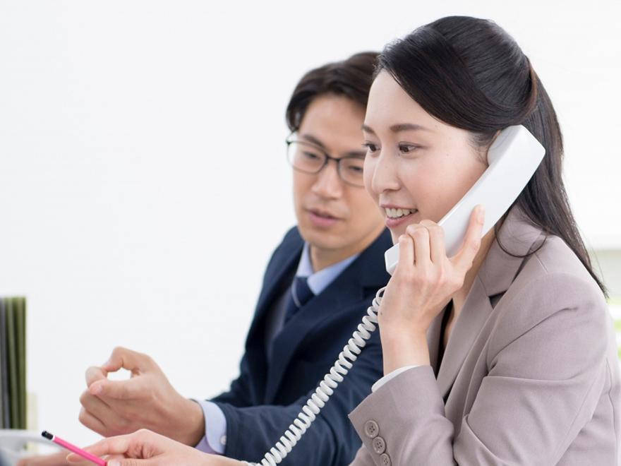 電話対応の練習をしている女性の写真